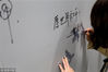 2018年12月5日，南京，乘坐地铁的市民纷纷停下，在“2018年南京大屠杀死难者国家公祭日和平许愿墙”上写下表达对那段历史的铭记和对和平的祈愿。
