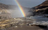 2018年12月8日，山西临汾，吉县黄河壶口瀑布飞溅的浪花和水雾在两岸的岩石和护栏上凝结，形成冰挂景观，与瀑布上空飞架的彩虹交相辉映，美不胜收。