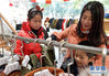 2月13日，在江西省南昌市新建区，胡海红在一家童装商店给孩子们买新衣。