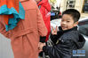 2月13日，在江西省南昌市新建区，胡海红牵着两个孩子外出逛街，儿子熊理超牵着妈妈的手十分高兴。

