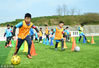 2018年2月3日，在广西来宾市忻城县森林公园足球场上，参加寒假足球训练营的孩子们正在练习带球。