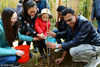 2018年3月10日，江苏镇江，外国留学生正在与社区志愿者一起植树。