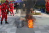 2018年03月13日，杭州市公安消防局联合各区市场监管局开展消防产品进社区宣传活动。工作人员现场展示一款高效能的水雾灭火器。视觉中国
