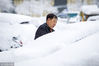 2018年3月15日，沈阳，一位私家车主正在清理车身上的积雪。
