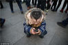 2014年01月29日，北京，在北京天安门广场，一名小男孩的笑脸发型引起周围游客的好奇。