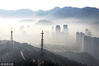 2018年3月25日，江苏省连云港市东部海滨城出现晨雾，城市建筑和山峦在雾中若隐若，缥缈的轻雾环绕在城区建筑和翠绿的山间，站在高处眺望，眼前的景色变化万千，恰似一幅水墨画。王春/视觉中国
