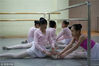 2018年3月18日，雄安新区。学员茜茜正给学员珠珠压脚背，班上的女孩一同学习芭蕾数年，关系十分亲密。