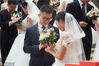 2018年4月21日，杭州，新人们在集体婚礼仪式上相互交换戒指。