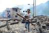 2018年4月21日，贵州黔东南，一小姑娘在凯里市三棵树镇南高村鱼寨组火灾现场搬运物品。