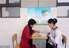 2018年5月10日，江苏扬州新华中学楼道里，老师正在为一名学生解答难题。