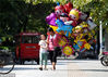 2015年08月21日，河南洛阳，余利娟带着儿子在周王城广场附近卖气球。视觉中国