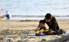 2018年1月20日，海南三亚，家长带孩子在海南省三亚市三亚湾海滩上游玩。
萧风/视觉中国