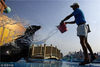 2009年8月12日，青岛弟弟海洋世界，饲养员为海狮洒水降温。伽佰列/视觉中国