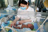2018年5月13日，在江苏省泰州市人民医院南院新生儿重症监护室（NICU），“临时妈妈”缪红珊在给新生患儿静脉注射。
