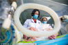 2018年5月13日，在江苏省泰州市人民医院南院新生儿重症监护室（NICU），“临时妈妈”医生樊晓艳和护士房京丽在给新生患儿检查身体。