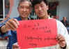 2018年5月13日，江苏南通，社区画家阮海麟（左）和南通中学藏族学生扎西曲加（右）展示分别用中文和藏文书写的“藏汉一家亲，共筑中国梦”。