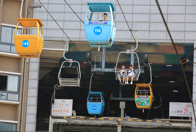 重庆景区索道“穿楼”而过 吸引游客感受惊险与刺激
