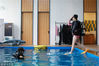 2018年4月24日，杭州。一名学员按住呼吸器和面罩跨步式入水，一跃而下，下面7米深的水池。鱼小胖在边上仔细观察每个动作，如有发现问题，她会让学员纠正过来再做一次。严格训练，为的是保证学员的安全。