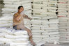 2013年7月18日，北京，一名小贩在面粉批发市场里休息时抽烟。Reuters/视觉中国