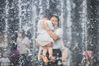 2017年5月18日，北京三里屯喷泉广场，一名女子抱着小孩戏水降温。当日，北京迎来今夏首个高温天，最高气温达35℃。麦田/视觉中国