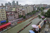 2018年6月12日，广州，在天河区车陂村举行一年度的龙舟比赛，天公不作美下起小雨，村民在岸边以及楼顶上冒雨围观比赛。