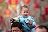 2008年2月9日，北京地坛庙会，人流如织。鼠年逛庙会蹲坐在长辈肩膀上的宝宝们表情各异。
