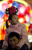 2010年2月27日，上海豫园，一位儿童骑在父亲的肩膀上欣赏花灯。今年的上海豫园新春民俗艺术灯会上，40余组以生肖虎和世博会为题材的大型彩灯烘托出浓浓的新春喜庆氛围，吸引众多游客赏灯游玩。