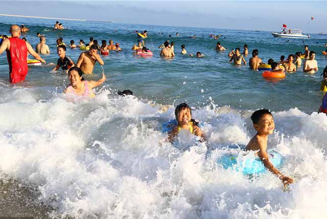 海南三亚海滩上游人如织 民众“洗龙水”闹端午