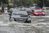 2018年6月6日，持续的强降雨导致海口市区多条道路出现积水，车辆涉险通过龙华路积水路段。