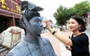 2018年6月30日，西安市最高气温达到了36度左右，在曲江新区一步行街上，两位活体“兵马俑”雕塑一动不动地站立在街头。女孩为兵马俑扮演者擦汗。