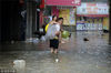 2018年7月12日，成都金堂县，群众经过积水的街道。