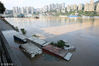 2018年7月14日，洪峰过境重庆主城，重庆市渝中区菜园坝竹木市场被洪水淹没。记者在现场看到，被洪水淹没地带已拉起警戒线，并实施交通管制。据了解，目前，长江洪峰已基本通过重庆主城区（菜园坝于14日5时处于峰值状态184.21米，超警3.78米，超保证水位0.78米，目前水位已降至184.10米）。 
图为重庆朝天门附近，洪水淹没了部分住人集装箱。 渝图/视觉中国
