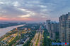The crimson clouds at sunset flushed the riverside area of Hexi New Town in Nanjing City on July 16.