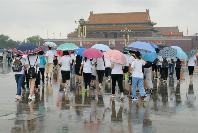 北京头伏遭遇大到暴雨 游客冒雨游览故宫天安门