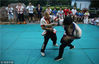 2018年7月17日，青岛。黄师傅亲自上阵，指导孩子们练习摔跤。