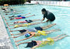 2018年7月22日，浙江金华，教练在武义县一游泳馆手把手教60多名中小学生游泳基本要领。