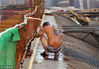 2013年8月6日，郑州持续高温，在工地上冒着酷暑干活的劳动者。
高架桥工地上实在太热了，干脆冲个凉。许俊文/视觉中国