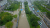 2018年7月6日，市民和车辆在江苏省扬州市街头涉水前行。
