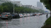 2018年7月6日，市民和车辆在江苏省扬州市街头涉水前行。