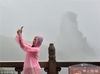 2018年7月6日，贵州铜仁，游客冒雨拍摄世界遗产地梵净山。