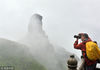 2018年7月6日，贵州铜仁，游客冒雨在世界遗产地梵净山用手机自拍。