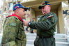 2018年8月9日，新疆巴音郭楞，委内瑞拉参赛队指挥官（右）将委内瑞拉武装力量军人佩戴的围巾，送给白俄罗斯参赛队指挥官（左），并亲手给他围在脖子上。