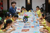 A teacher gives dough modeling instructions to children from Nanjing, Jiangsu province, Aug 16. The craftsmanship is an old tradition of Nanjing and has been listed as a local intangible cultural heritage. 