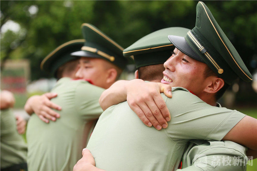 图为退伍老兵与留队士兵相互拥抱.