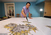 2018年7月26日，浙江湖州，在湖州市吴兴区织里镇，农民画家张佰荣正在自家院子种植的向日葵前写生作画。