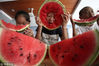 2018年8月6日，江苏省扬州市杉湾花园社区的小朋友在吃西瓜“啃秋”。孟德龙/视觉中国