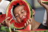 2018年8月6日，江苏省扬州市杉湾花园社区的小朋友在吃西瓜“啃秋”。孟德龙/视觉中国