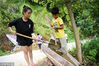 2018年8月5日，广西柳州，在广西柳州市三江侗族自治县洋溪乡勇伟村，梁宏月带着弟弟利用简易的滑梯转运沙子。