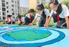 2018年9月13日，河北秦皇岛海港区东华里小学学生展示彩绘的“保护臭氧层”环保长卷。