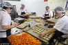 2018年9月17日，在浙江省杭州市临安区天目山镇一家食品厂内，员工在手工制作中秋月饼。